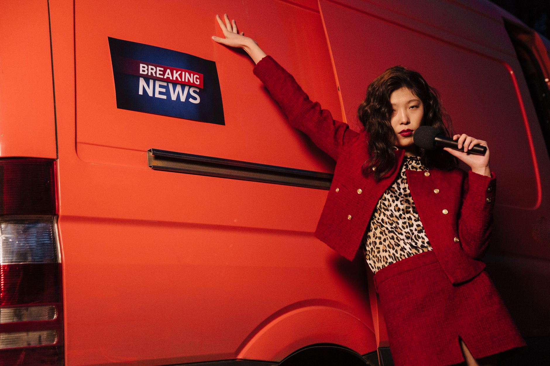 Fashionable reporter with microphone posing dramatically next to a news van. — CBD Oil For Dogs Anxiety