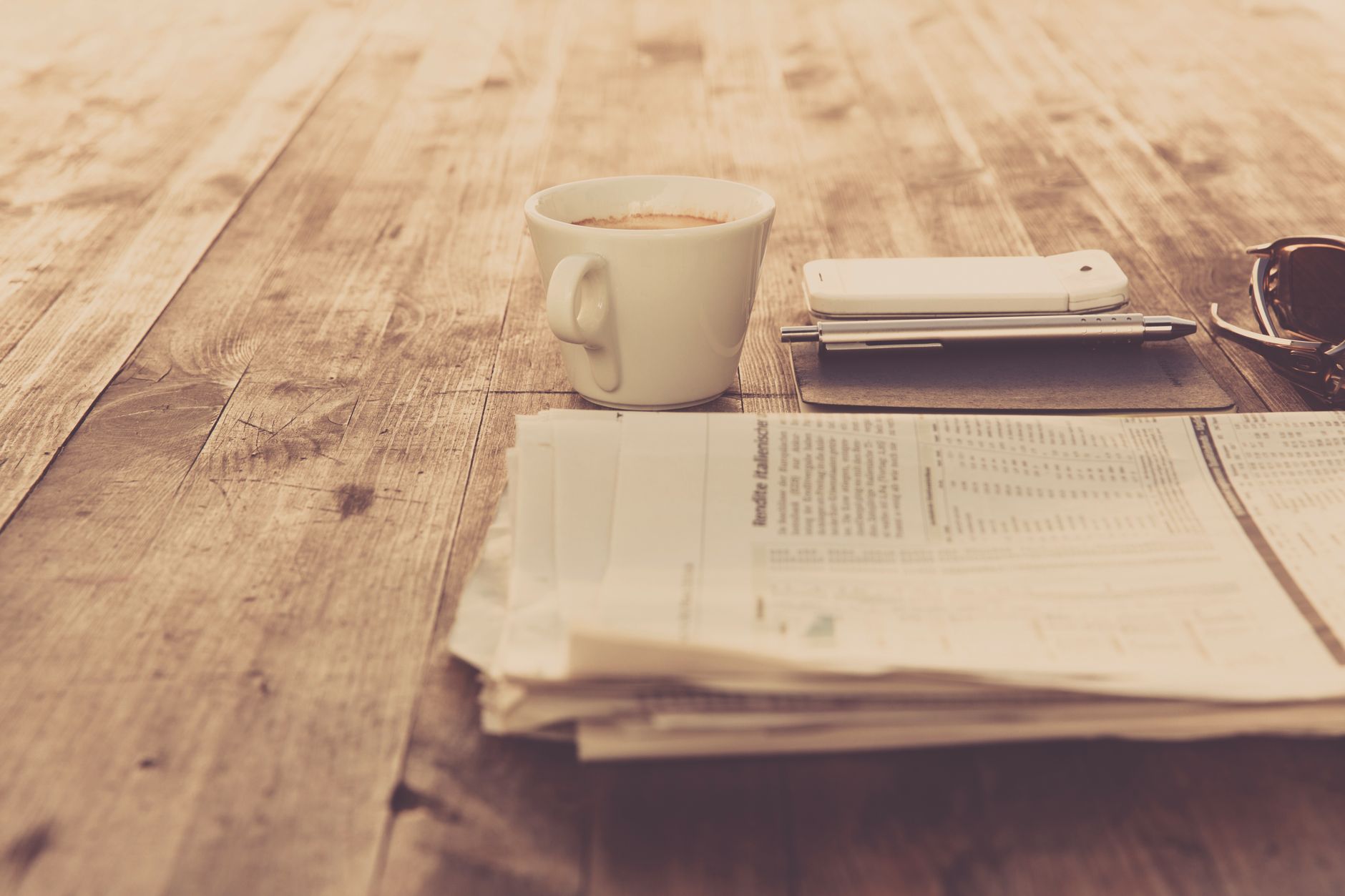 A warm vintage morning setup with coffee, newspaper, and smartphone on wooden table. — Die Kundenmeinungen zum Beef Casino im