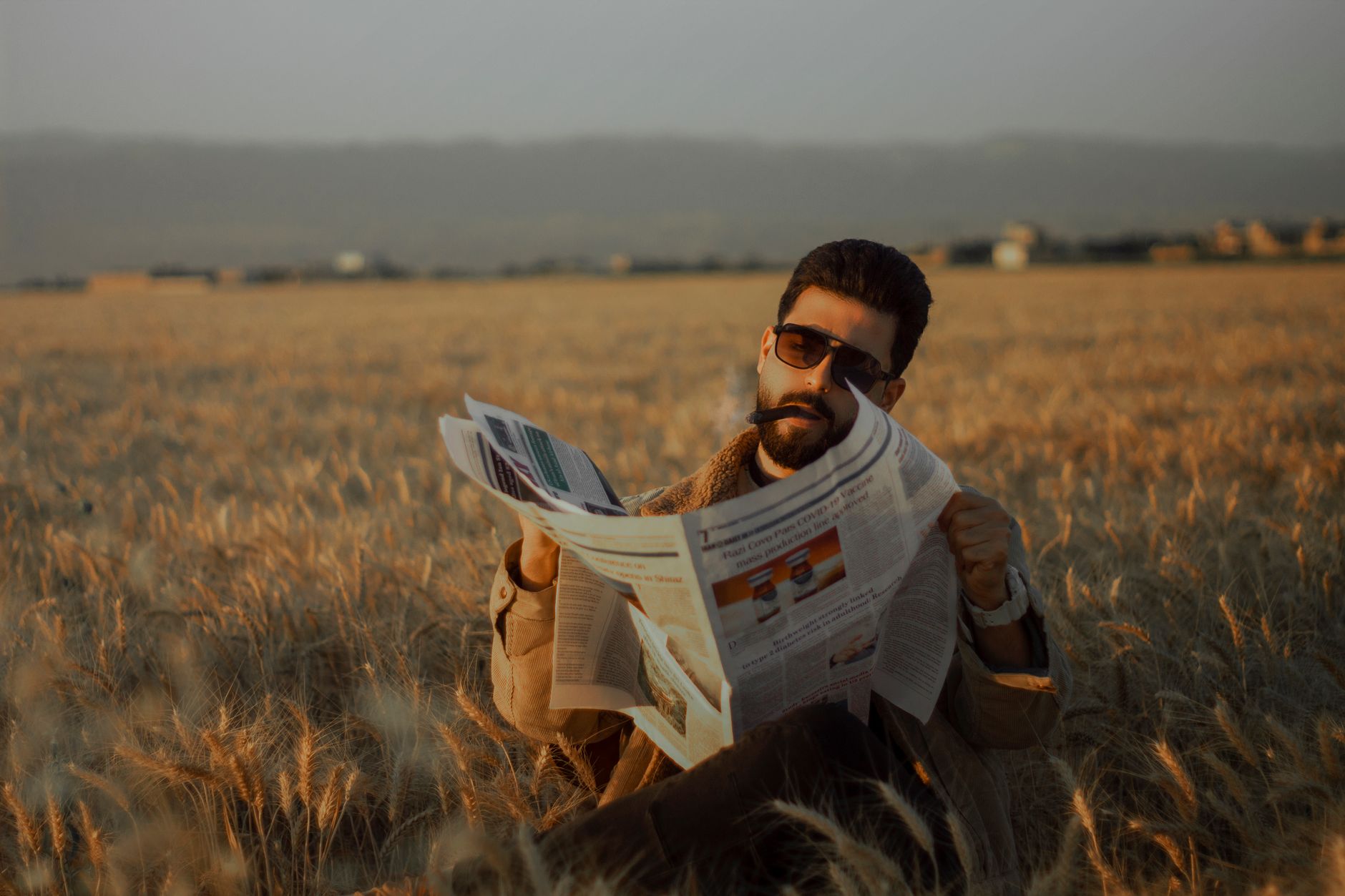 Middle-aged man sitting in a serene wheat field, reading a newspaper during the day. — Les astuces pour des retraits rapides