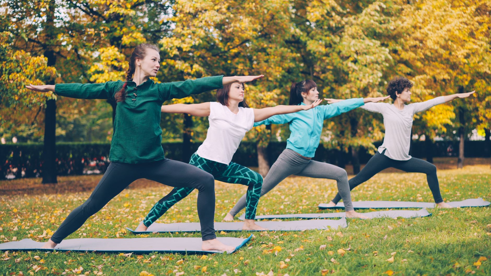 Four women practicing yoga in a park surrounded by autumn foliage. — Over 400 companies claim that they can hold the needed e