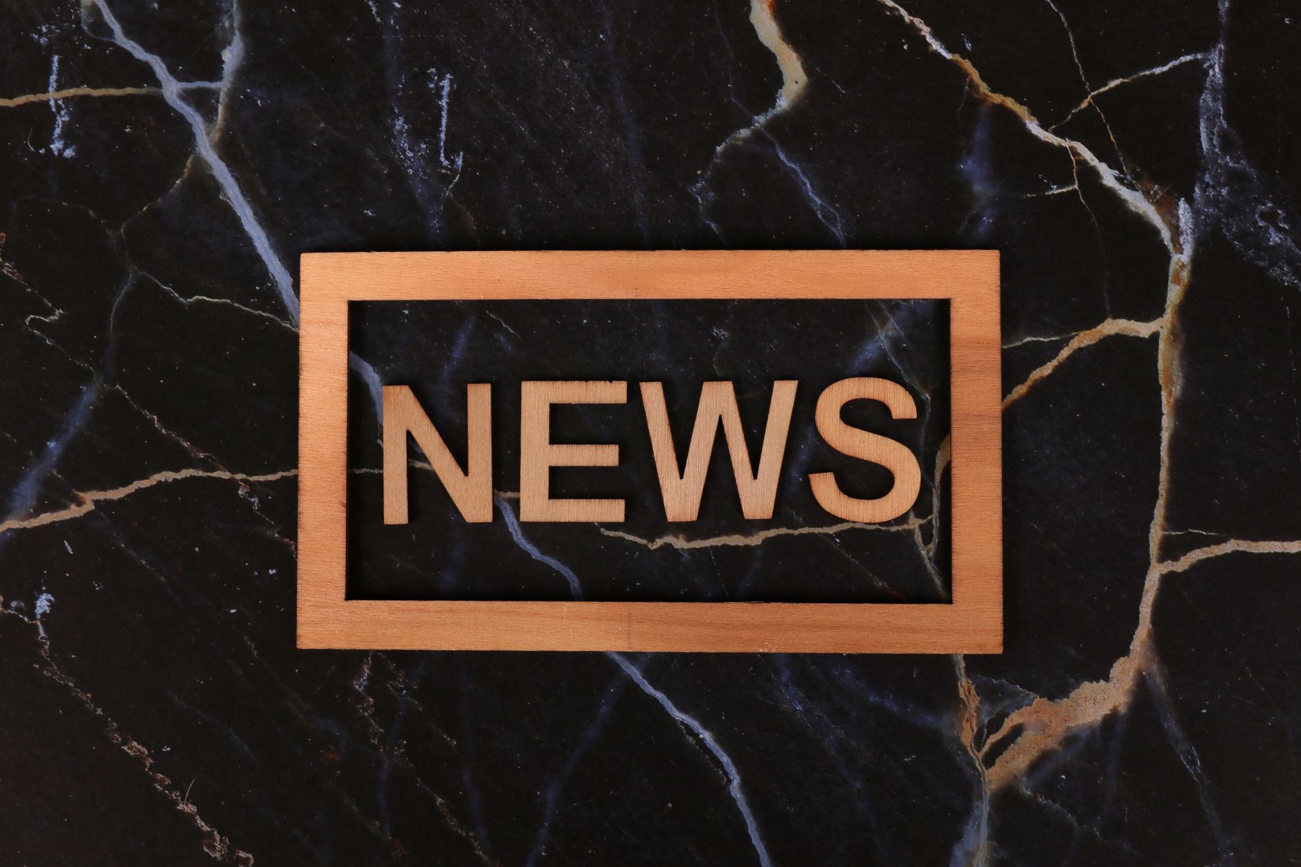 Wooden text of 'news' outlined on a dark, marbled surface, creating a striking contrast. — Peut on qualifier Millionz Casino