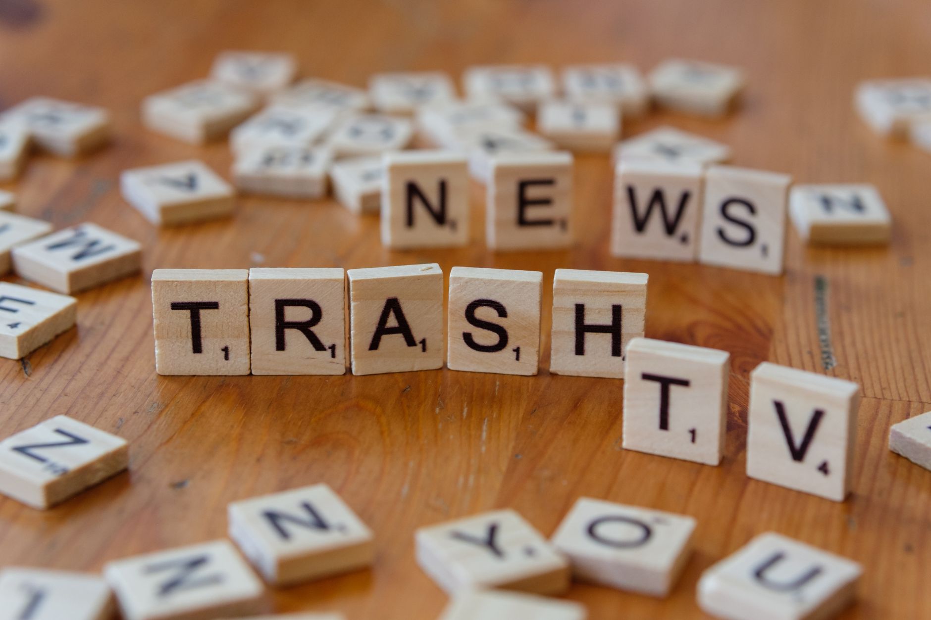 Close-up of wooden letter tiles spelling out Trash TV News on a table. — Planet 7 Casino et l’examen détaillé des options de