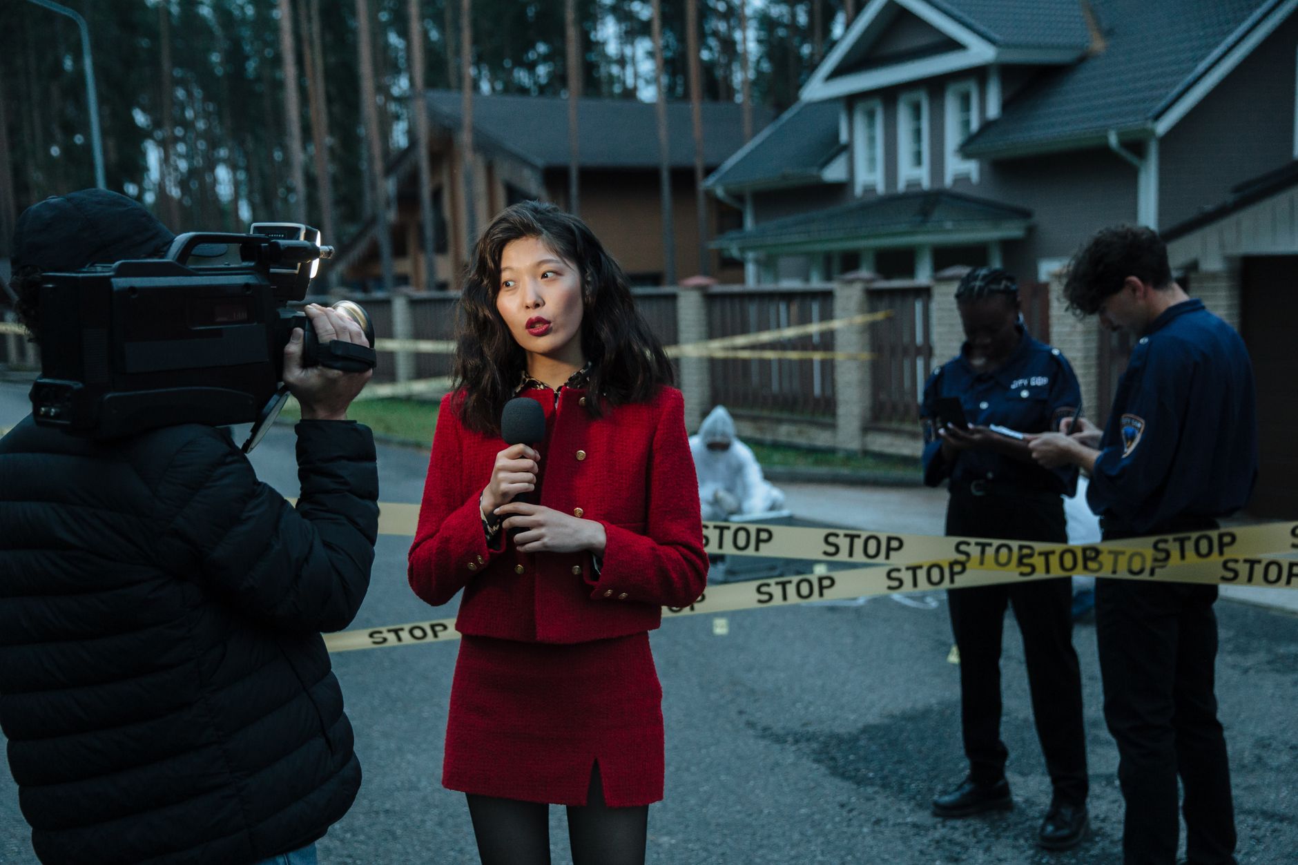 A journalist reporting from a crime scene with police officers and cameraman. — Prêt à plonger dans l’univers mystérieux de H