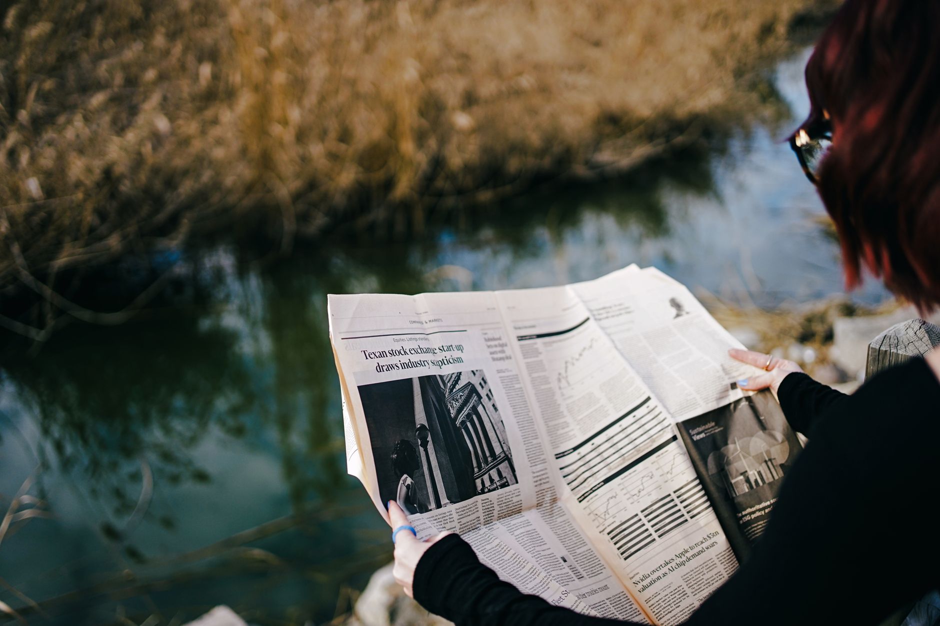A person enjoys reading a newspaper by a tranquil pond on a sunny day. — Superbet Casino bonus anniversaire une nouveauté à n