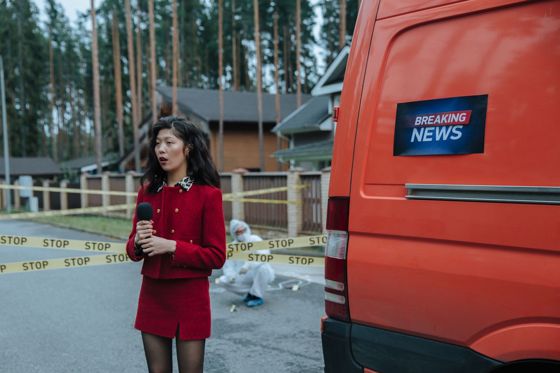 Female reporter in red outfit at an outdoor crime scene with warning tape and a news van. — Warum Rich Royal Casino nicht ign