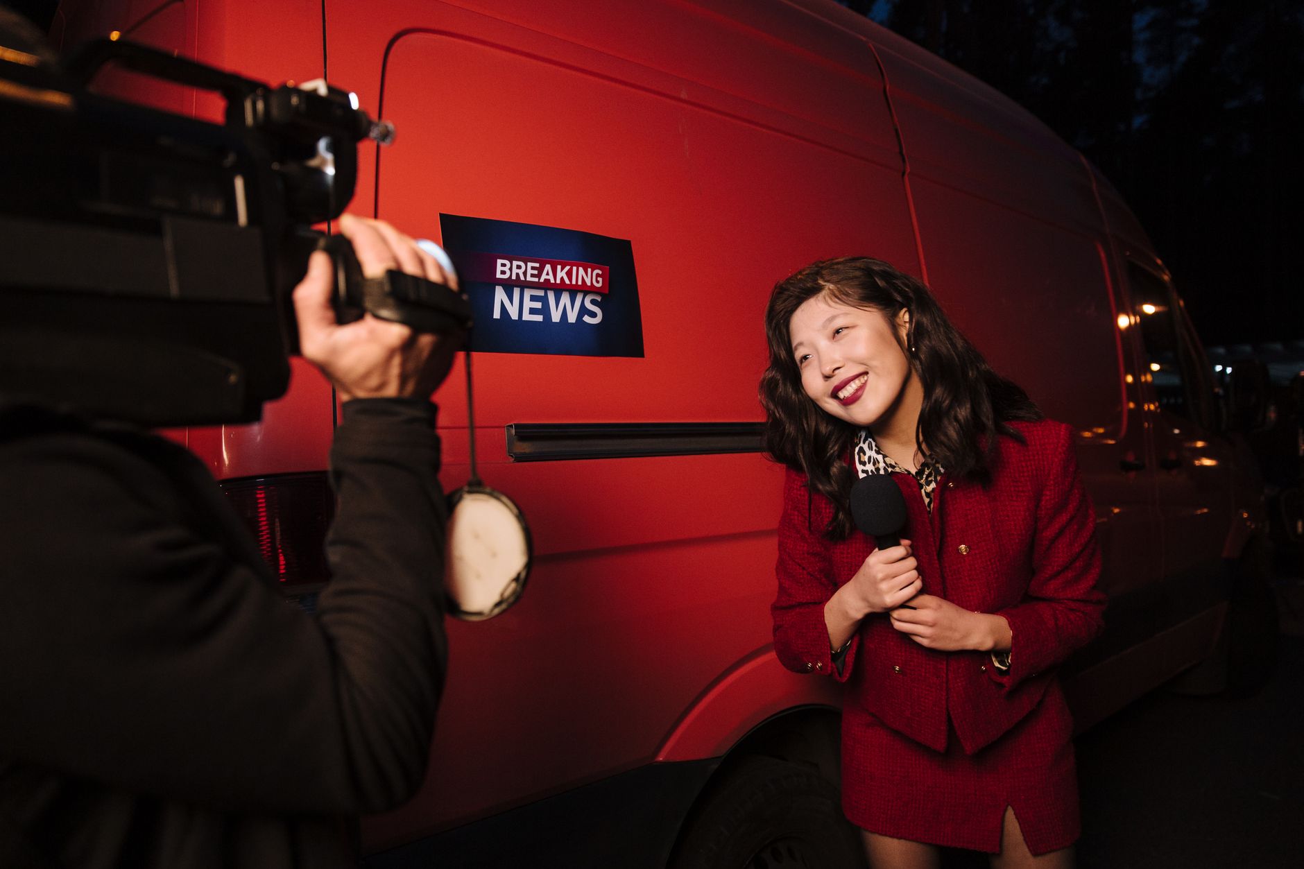 Asian female reporter in a red blazer reporting live on the news outdoors in the evening. — Was dürfen Sie nicht über VIP Cas