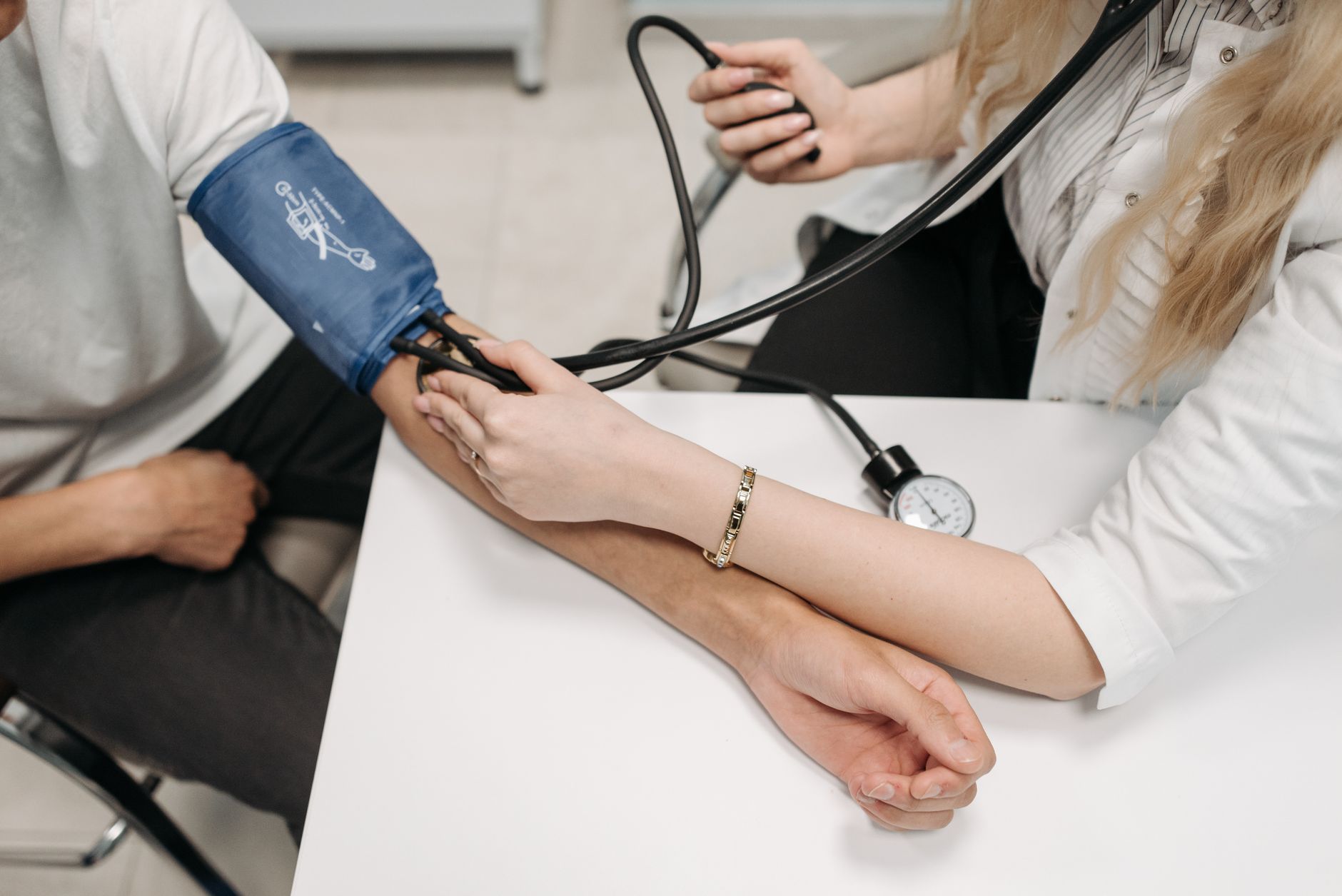 A doctor measures a patient's blood pressure with a sphygmomanometer during a consultation. — What's an Extruded Tooth? What'