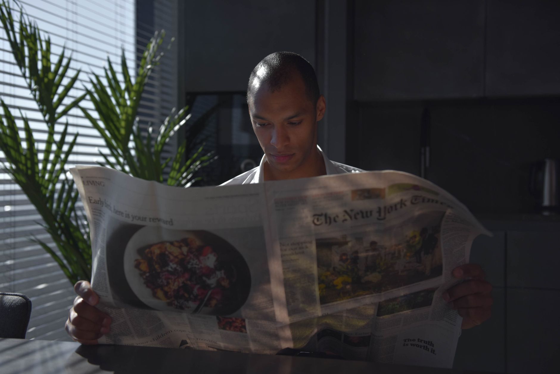Businessman focused on reading newspaper in a sunny indoor office setting. — Wie viel kann man bei Royal Coala Casino gewinne