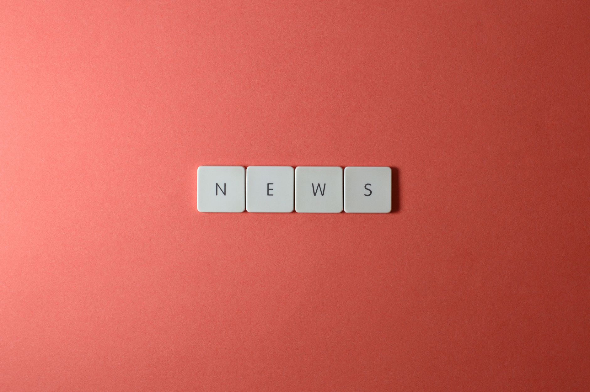 Close-up of keyboard keys spelling 'NEWS' on a red background, minimalist style. — À quoi ressemble l’éco système complet de